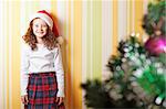 beautiful little girl standing near christmas tree