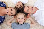 Smiling young family lying on the floor with heads together