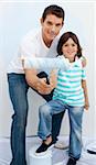 Father and his son paiting a room in their new house