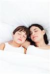 Affectionate mother and her son sleeping on a bed