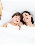 Smiling mother and her son lying on a bed