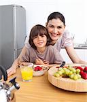 Happy mother and her child having breakfast in the kitchen