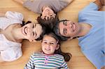 Lively family lying on the floor with heads together