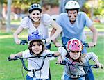 Happy family riding a bike in a park