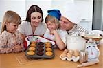 Merry family presenting their muffins in the kitchen