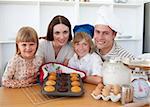 Cheerful family presenting their muffins in the kitchen