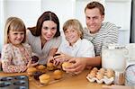 Smiling family eating their muffins in the kitchen