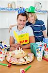 Smiling father celebrating his birthday with his son in the kitchen