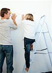 Father and his son decorating a room after move in