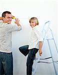 Smiling father and his son decorating a room after move in