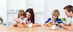 Happy family eating breakfast in the kitchen at home