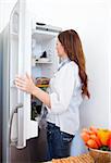 Attractive woman looking for something in the fridge at home