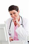 Smiling female doctor working at a computer against a white background