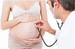 Gynecologist examining a pregnant woman in his surgery