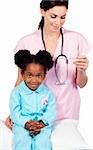 Female nurse taking little girl's temperature against a white background