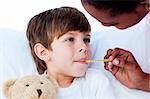 Close-up of a doctor taking child's temperature in a hospital