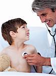 Mature male doctor checking little boy's pulse in a hospital