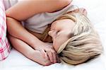 Blond young woman sleeping on a bed at home
