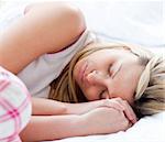 Charming young woman sleeping on a bed at home