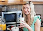 Smiling woman having an healthy breakfast in a kitchen at home