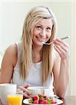 Happy woman having an healthy breakfast at home