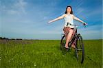 Happy young woman relaxing over a vintage bicycle