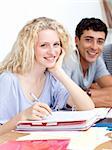 Happy teen girl studying in the library with her friends. Concept of education