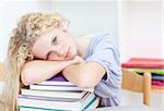 Blond teeenager sleeping in a library after studying long time