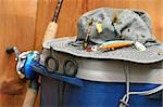 Fishing tackle box, hat and reel on wood