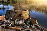 Traditional fly-fishing rod with equipment beside a lake late afternoon