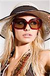 blond girl with summer hat and sunglasses posing and taking sun