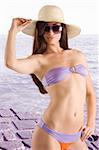 sensual beautiful brunette with long hair wearing a bikini swimsuit hat and sunglasses