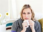 Unhealthy woman sitting on a sofa with a handkerchief