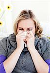 Diseased woman use a handkerchief sitting on a sofa