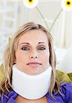 Portrait of a woman with a neck brace lying on a sofa