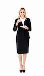 A happy businesswoman holding a cup of tea wearing a black suit
