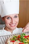 Radiant female chef cooking a pizza in a kitchen