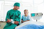 Attractive surgeon explaining a surgery to a child patient in a hospital