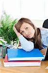 Upset young businesswoman sitting at her desk in the office