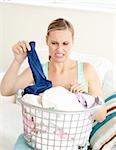 Unhappy woman doing her laundry at home