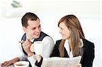 Cheerful couple of business people having breakfast in the kitchen