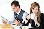 Serious couple of business people having breakfast in the kitchen