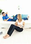 Happy couple reading book in the living-room at home