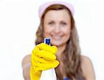 Smiling young woman cleaning against a white background