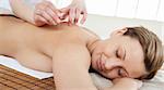 Acupuncture needles on a beautiful woman's back in a Spa center