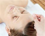 Acupuncture needles on an attractive woman's head in a Spa center