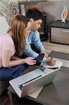 young couple at home with  modern living room indoor working on laptop on house finance and planing