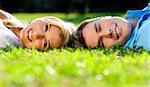 Young couple lying on the grass outside together