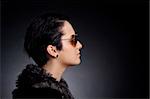 Fashion woman portrait wearing sunglasses on dark background