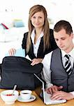 Businesswoman packing her bag businessman using laptop  in the kitchen